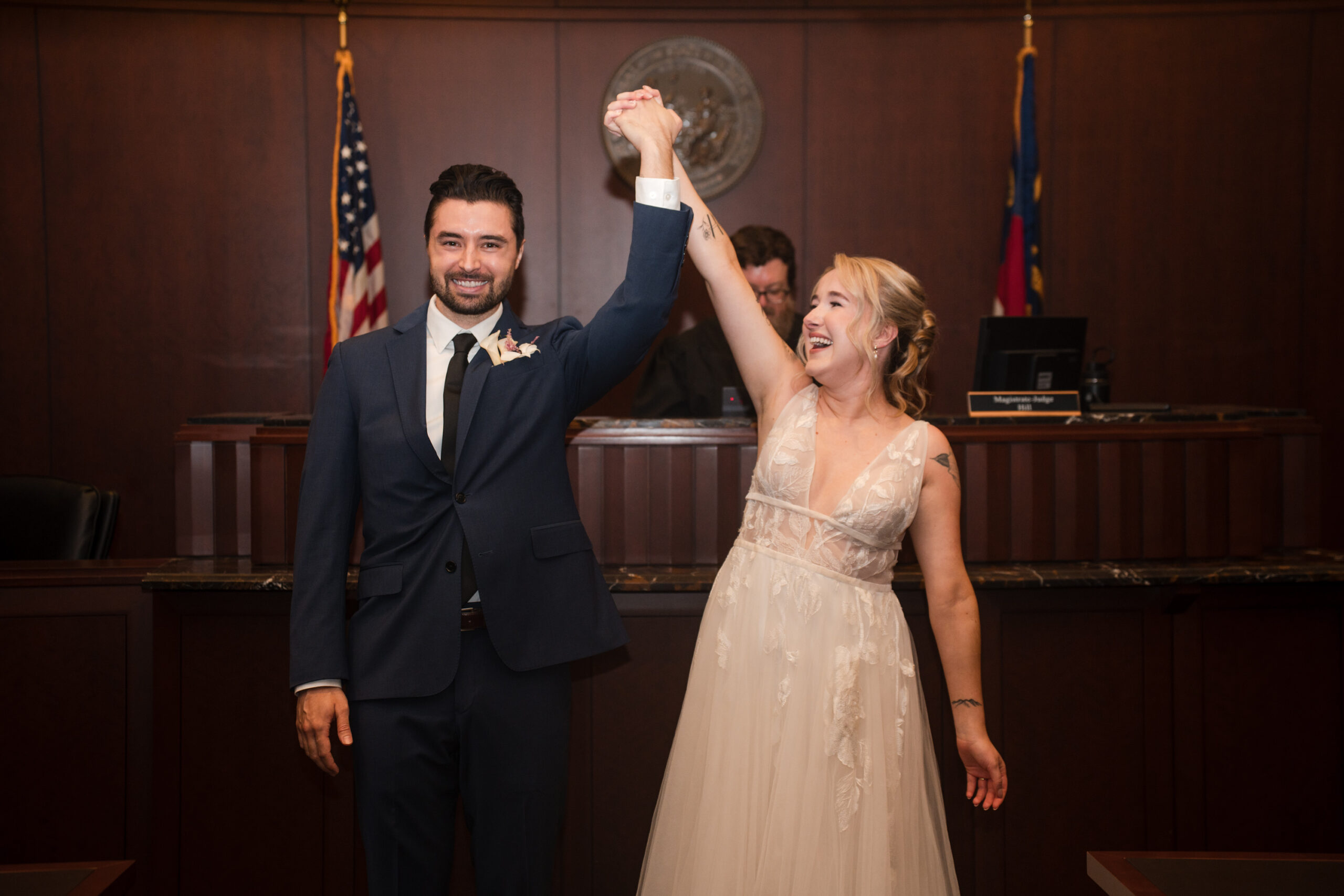 Bride and groom cheering after a Raleigh Courthouse wedding ceremony.